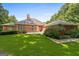 View of a brick home with a spacious lawn and a private backyard, great for outdoor activities at 127 Darwish Dr, Mcdonough, GA 30252