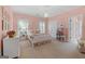 Charming pink bedroom with plush carpeting, a chandelier, and ensuite bathroom access at 127 Darwish Dr, Mcdonough, GA 30252