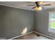 Neutral bedroom with a ceiling fan, carpeting, and natural light streaming through the window at 7138 Rockland Rd, Lithonia, GA 30038