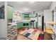 Cozy kitchen featuring light green cabinetry, stainless steel appliances, and a colorful decorative rug at 7138 Rockland Rd, Lithonia, GA 30038