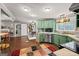 Open-concept kitchen featuring vibrant green cabinetry, bar-top countertop and adjacent dining area at 7138 Rockland Rd, Lithonia, GA 30038