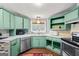 Well-lit kitchen with green cabinets, stainless steel appliances and tile backsplash at 7138 Rockland Rd, Lithonia, GA 30038