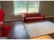 An open living space with a large window, rug, and red sofa at 7138 Rockland Rd, Lithonia, GA 30038