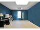 Empty blue room with large window and desk offers versatility for a home office or extra room at 8870 Dornoch Cir, Winston, GA 30187