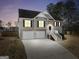 Two-story home featuring a two-car garage and stairway to front door at dusk at 8870 Dornoch Cir, Winston, GA 30187