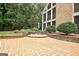 Outdoor patio and seating area with manicured landscaping and mature trees, providing a relaxing and inviting backyard space at 104 Hidden Springs Ln, Peachtree City, GA 30269