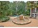Beautifully landscaped backyard showcases a large brick patio with a water feature, creating a serene outdoor living space at 104 Hidden Springs Ln, Peachtree City, GA 30269