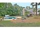 Backyard boasts large swimming pool, mature trees, and beautiful landscaping at 104 Hidden Springs Ln, Peachtree City, GA 30269