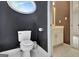 Chic black and white powder room with an oval window providing ample natural light at 104 Hidden Springs Ln, Peachtree City, GA 30269