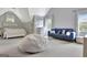 Comfortable bedroom with queen bed, a blue loveseat, and a cozy beanbag offers a relaxing retreat at 104 Hidden Springs Ln, Peachtree City, GA 30269