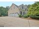 Home exterior featuring a three-car garage, manicured landscaping, and a spacious driveway at 104 Hidden Springs Ln, Peachtree City, GA 30269