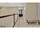 Hallway featuring neutral carpet, wall paint, and a decorative bench alongside a dark wood railing at 104 Hidden Springs Ln, Peachtree City, GA 30269