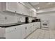 A bright white kitchen features stainless appliances, tile backsplash, and lots of counter space at 104 Hidden Springs Ln, Peachtree City, GA 30269