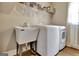 Functional laundry room featuring a utility sink and modern washer and dryer set for convenient home chores at 104 Hidden Springs Ln, Peachtree City, GA 30269