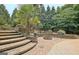 Inviting outdoor space featuring a stone patio with a built-in fire pit and elegant landscaping for cozy gatherings at 104 Hidden Springs Ln, Peachtree City, GA 30269