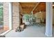 Covered stone patio with a brick fireplace and outdoor seating area overlooking the backyard at 104 Hidden Springs Ln, Peachtree City, GA 30269