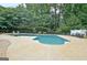 Refreshing pool surrounded by concrete patio and lush landscaping, perfect for outdoor relaxation at 104 Hidden Springs Ln, Peachtree City, GA 30269