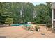Inviting backyard oasis featuring a sparkling pool, lush landscaping, and an expansive brick patio for outdoor entertaining at 104 Hidden Springs Ln, Peachtree City, GA 30269