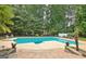 Beautiful pool area surrounded by lush landscaping, featuring a diving board, sun loungers and a serene, private setting at 104 Hidden Springs Ln, Peachtree City, GA 30269
