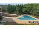 A gunite pool is surrounded by meticulous landscaping, with a multi-tiered patio and pool furniture at 104 Hidden Springs Ln, Peachtree City, GA 30269