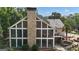 A two-story screened porch with an exterior stone fireplace, leading out to a multilevel patio and gunite pool at 104 Hidden Springs Ln, Peachtree City, GA 30269