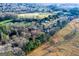 Wide aerial view showcasing neighborhood amidst a mix of open fields and wooded areas at 402 Stonebrooke Dr, Auburn, GA 30011