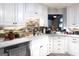 Close-up of updated kitchen featuring white cabinets and a farmhouse sink at 402 Stonebrooke Dr, Auburn, GA 30011