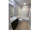 Well-lit bathroom featuring a shower-tub combo, white toilet, and granite-topped vanity at 7560 Taylor Rd # 1, Riverdale, GA 30274