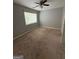 Neutral bedroom with large window, ceiling fan, and carpeted floors at 7560 Taylor Rd # 1, Riverdale, GA 30274