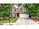 Charming brick home with a well-maintained lawn, two-car garage, and mature trees offering shade at 2009 Parador Aly, Mcdonough, GA 30253