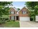 Inviting brick home with a manicured front lawn, black shutters, and an attached two-car garage at 2009 Parador Aly, Mcdonough, GA 30253