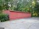 Exterior view of a red barn, surrounded by trees and a concrete parking area at 3025 Ebenezer Rd., Se Rd, Conyers, GA 30094