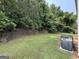 Lush backyard features a stone retaining wall, blending nature and architectural design at 3205 Anneewakee Falls Pkwy, Douglasville, GA 30135