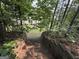 View down stone stairs toward a house with a well-maintained backyard and mature landscaping at 3205 Anneewakee Falls Pkwy, Douglasville, GA 30135