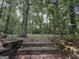 Backyard steps lead to a wooded area, creating a natural transition from the yard at 3205 Anneewakee Falls Pkwy, Douglasville, GA 30135