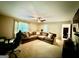 Bright living room with a large sectional couch, ceiling fan, and large windows at 3205 Anneewakee Falls Pkwy, Douglasville, GA 30135