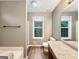 Well-lit bathroom featuring a granite countertop vanity, window, and shower with a tub for a relaxing experience at 106 Oakwood Cir, Stockbridge, GA 30281