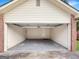 Open garage with a white door and gray floors providing space for parking and storage at 106 Oakwood Cir, Stockbridge, GA 30281