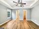 Bright main bedroom with tray ceilings and wood floors leading to an ensuite bathroom at 106 Oakwood Cir, Stockbridge, GA 30281