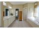 Spacious primary bathroom featuring double vanities, a large window, and a soaking tub at 100 Clydesdale Ct, Tyrone, GA 30290
