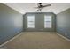 Spacious carpeted bedroom with a ceiling fan and large windows, offering plenty of natural light at 100 Clydesdale Ct, Tyrone, GA 30290