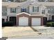 A view of the townhome's facade, showcasing the garage, neutral siding, and 'For Rent' sign at 106 Ne Ellis Dr # 106, Conyers, GA 30012