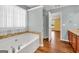 A full bathroom with a large tub and adjacent view to bedroom at 3338 Gardenside Walk, Loganville, GA 30052