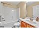 This bathroom has a shower-tub combo with white tile and wood vanity at 3338 Gardenside Walk, Loganville, GA 30052