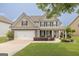 Charming two-story home with a well-manicured lawn, two-car garage, and inviting front porch at 3338 Gardenside Walk, Loganville, GA 30052