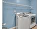 A practical laundry room with modern washer and dryer, plus overhead shelving at 3338 Gardenside Walk, Loganville, GA 30052