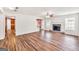 Open concept living room featuring hardwood floors, fireplace, and access to kitchen and stairs at 3338 Gardenside Walk, Loganville, GA 30052