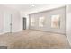 Spacious carpeted bedroom with three bright windows and a white door at 6857 Louis Dr, Locust Grove, GA 30248