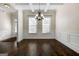 Elegant dining room featuring hardwood floors, wainscoting, coffered ceiling, and a stylish chandelier at 6857 Louis Dr, Locust Grove, GA 30248