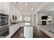 Open-concept kitchen with white cabinetry, stainless steel appliances, granite countertops, and hardwood flooring at 6857 Louis Dr, Locust Grove, GA 30248